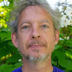 Portrait of a man with white hair by greenery